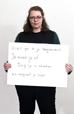 Vrouw met bord met de tekst "Hier ga ik je begraven. Ik maak je af. Snij je in stukken en begraaf je hier"